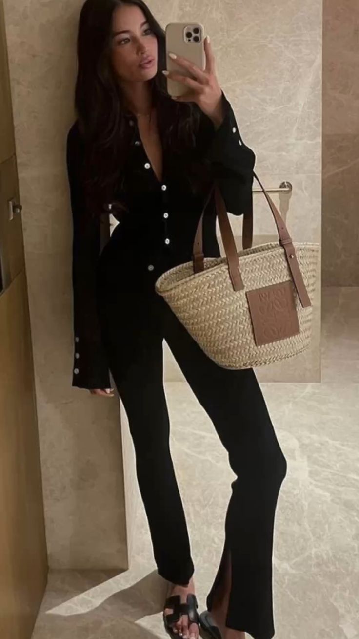 Black jumpsuit complemented by a LOEWE straw bag